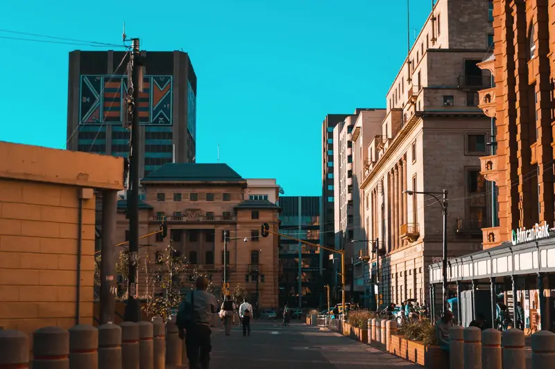 Pedestrians walking between office buildings on a Johannesburg street