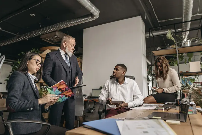 Colleagues working through documents together at a meeting table